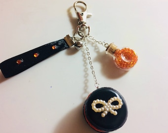 Matching black and orange macaroon Keyring has a mini-fiole filled with orange beads.