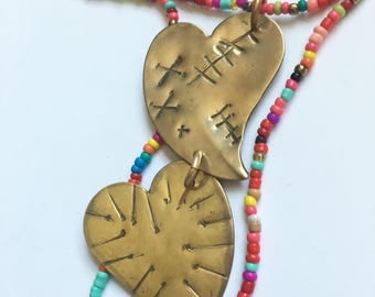 Healing pincushion hearts in brass with beaded necklace