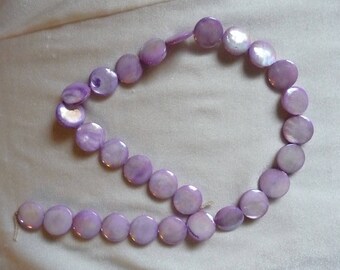 Beads, Mother of Pearl, Shades of Purple, 15mm Flat Round Coin. Sold per 15 inch strand. There are 28 beads on the strand.
