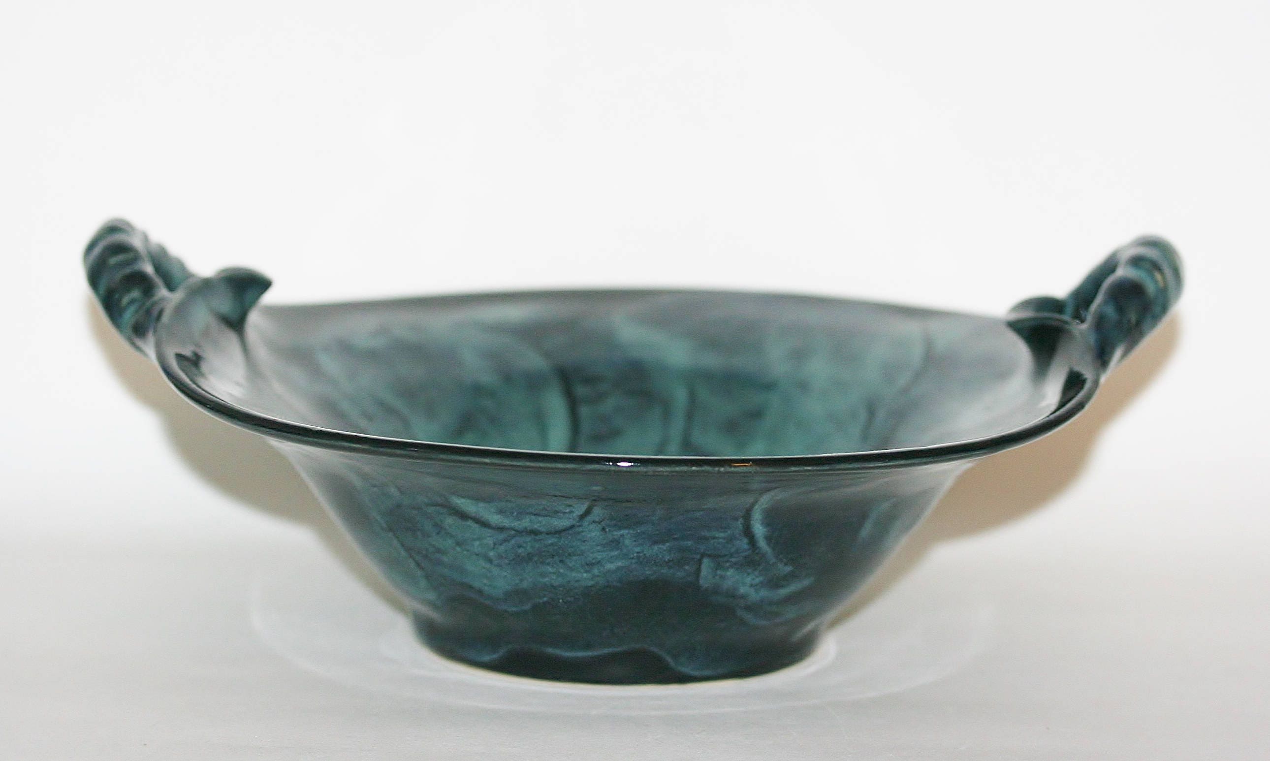 Unique handmade ceramic serving bowl with carved handles.