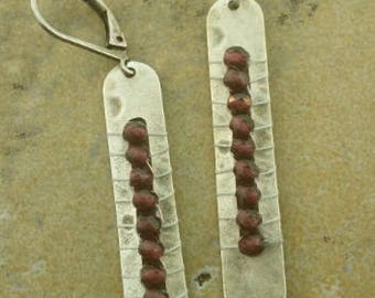 Long silver earrings with woven garnet