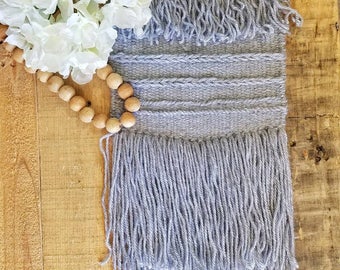 Hand woven wall hanging in a blue gray