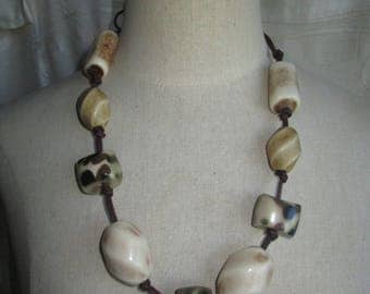 necklace or belt of khaki and ivory beads and brown leather cord