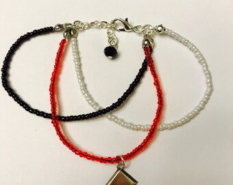 Harley Quinn inspired bracelet: triple strand red, white, black, glass bead bracelet with diamond shape charm