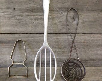 Vintage kitchen utensils: primitive beater, egg separator and vegetable peeler