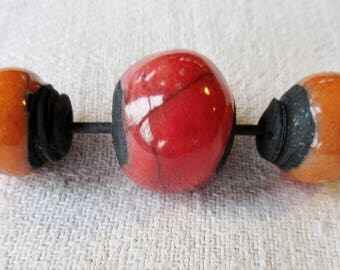 set of 3 round beads orange or red on black ground