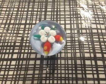 Large glass paperweight button of white flower.