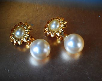 Classy vintage 80s gold tone metal , sunflower shape clip on earrings with a large , white ,faux ,dangle pearl. Made by Maeve Carr.