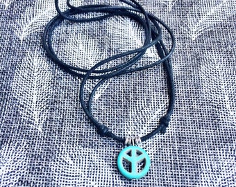 Men's boho necklace. Zwart koord vegan, dikte 1 mm, met turquoise howlite Peace bedel, 14 mm. Met 2 schuifknoopjes.