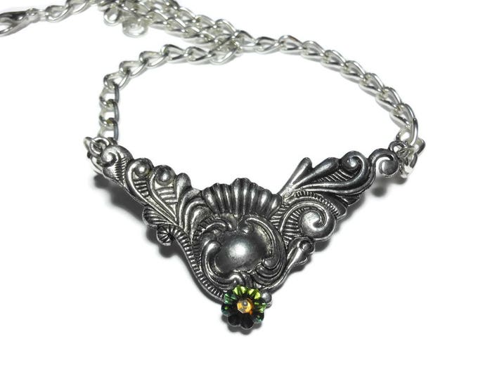 Silver plated swirl necklace, green Swarovski crystal marguerite lochrose flower below ornate focal with a eye catching plated curb chain