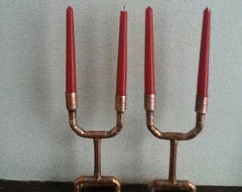 A matching pair of copper double candlesticks