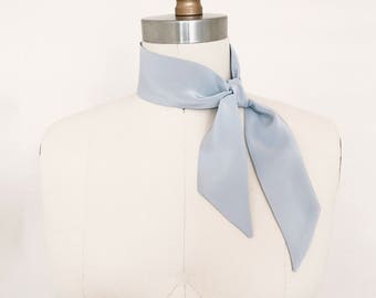 Silk kerchief in pale blue stone. 33"x2" Easy care silk scarf to wear as a bandana, ascot neck-tie, hair tie or choker in faded denim blue.