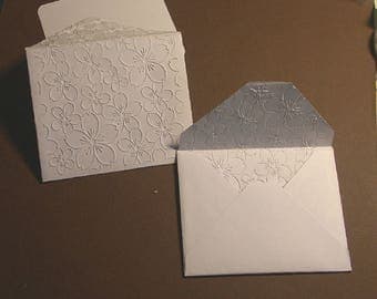 8 small white envelopes embossed, floral pattern