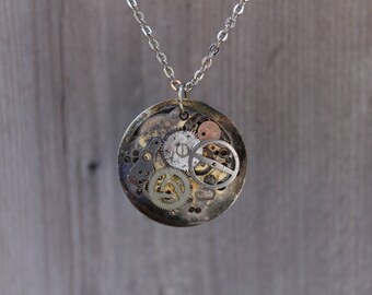 Unique vintage victorian steampunk recycled upcycled and clock parts costume jewlery necklace with exposed gears in gold and silver tones.