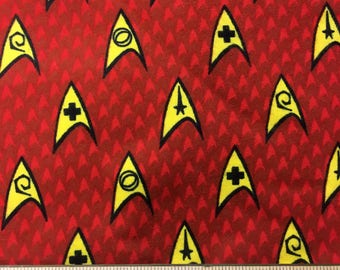 Star Trek Emblems on red flannel fabric, 42" wide, 100% cotton