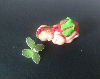 polymer clay with a green and pink dress baby