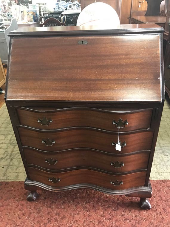 Dresser desk with slant front writing surface and serpentine drawers