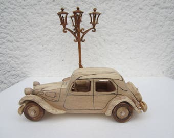 Under the fire of lights. Wooden miniature of a Citroen traction before 11 CV car.