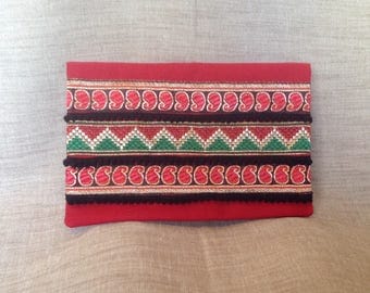Pocket flap with red fabric, ribbons and tassels.