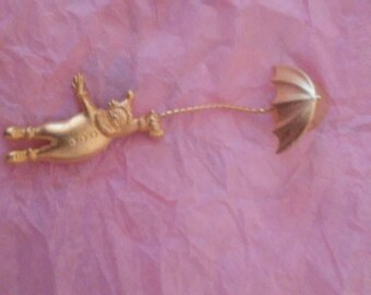 Gold tone clown holding umbrella